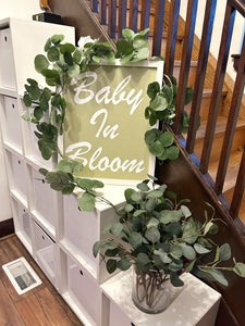 Baby in Bloom sign and greenery
